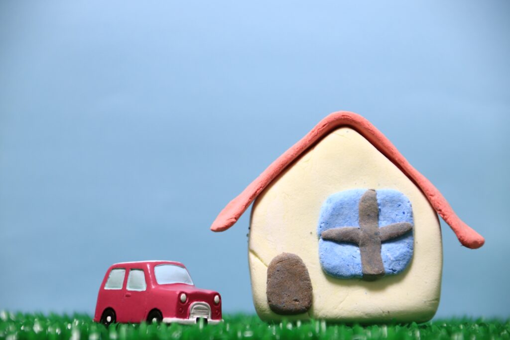 人工芝の庭に建つ家と停めてある車